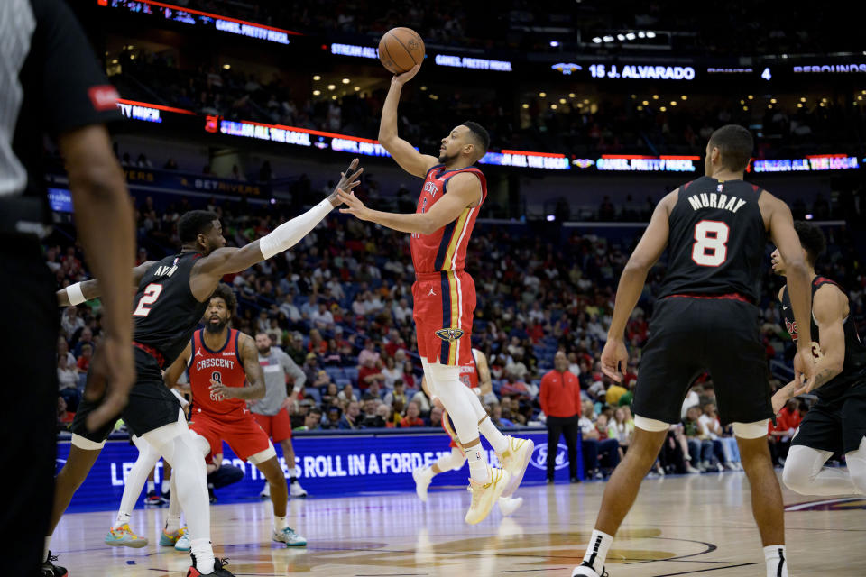 New Orleans Pelicans guard CJ McCollum (3) shoots against Portland Trail Blazers center Deandre Ayton (2) during the first half of an NBA basketball game in New Orleans, Saturday, March 16, 2024. (AP Photo/Matthew Hinton)