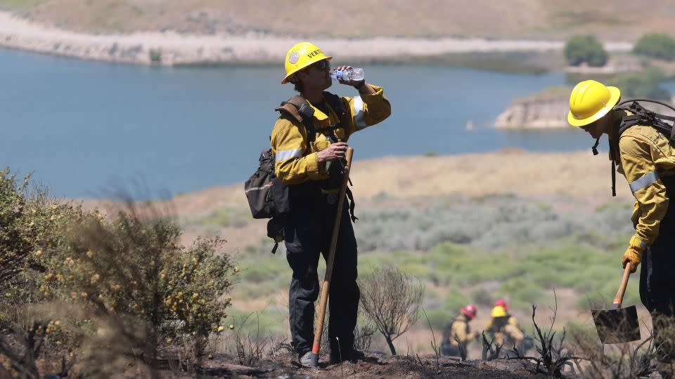 A Los Angeles firefighter takes a drink of water while working the Cherry Fire in triple digit heat near Gorman, California, on Wednesday. - David Swanson/AFP/Getty Images