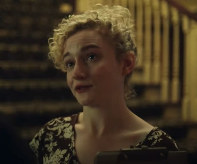 Julia Garner as Ruth Langmore speaking to someone while holding a clipboard