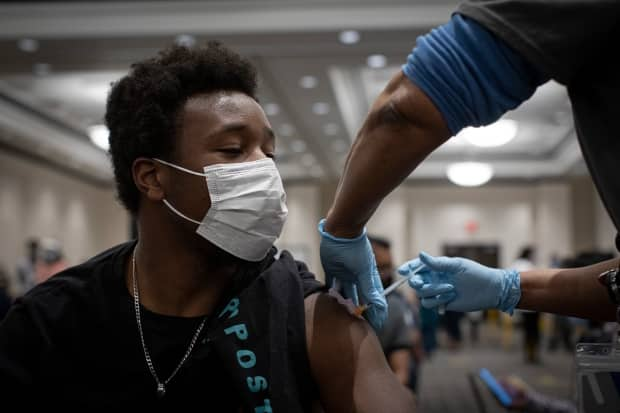 Kevin Allen, 23, gets his first dose of the Pfizer COVID-19 vaccine at a clinic in Mississauga earlier this year. (Evan Mitsui/CBC - image credit)