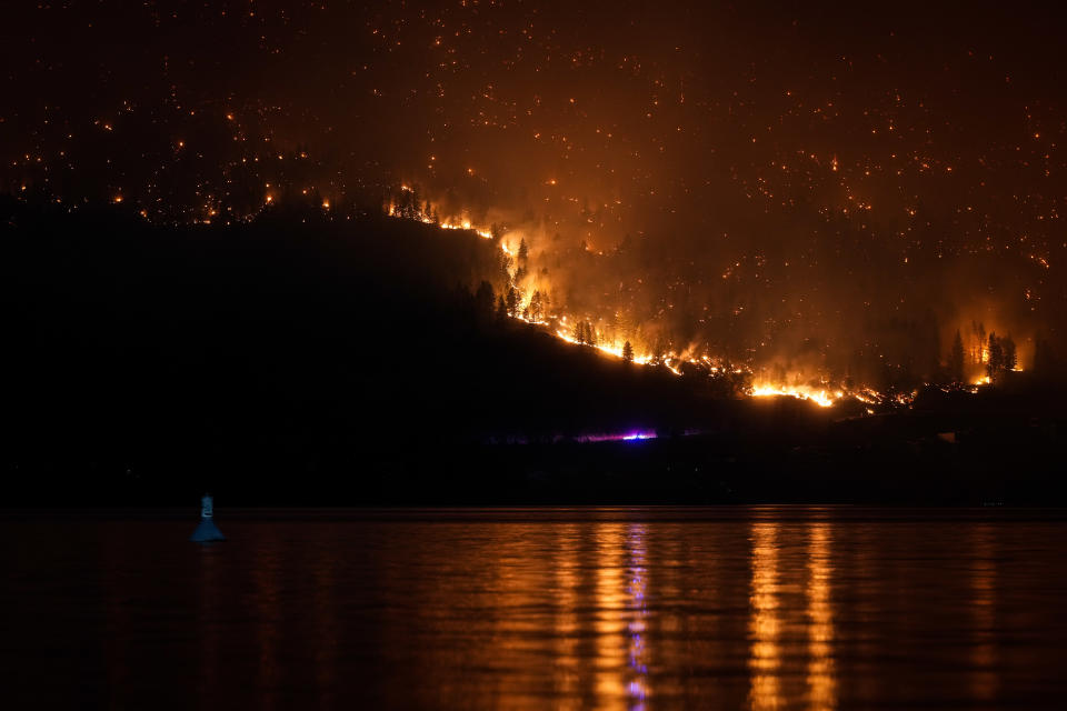 The McDougall Creek wildfire burns on the mountainside above lakefront homes in West Kelowna, B.C., on Friday, August 18, 2023. THE CANADIAN PRESS/Darryl Dyck