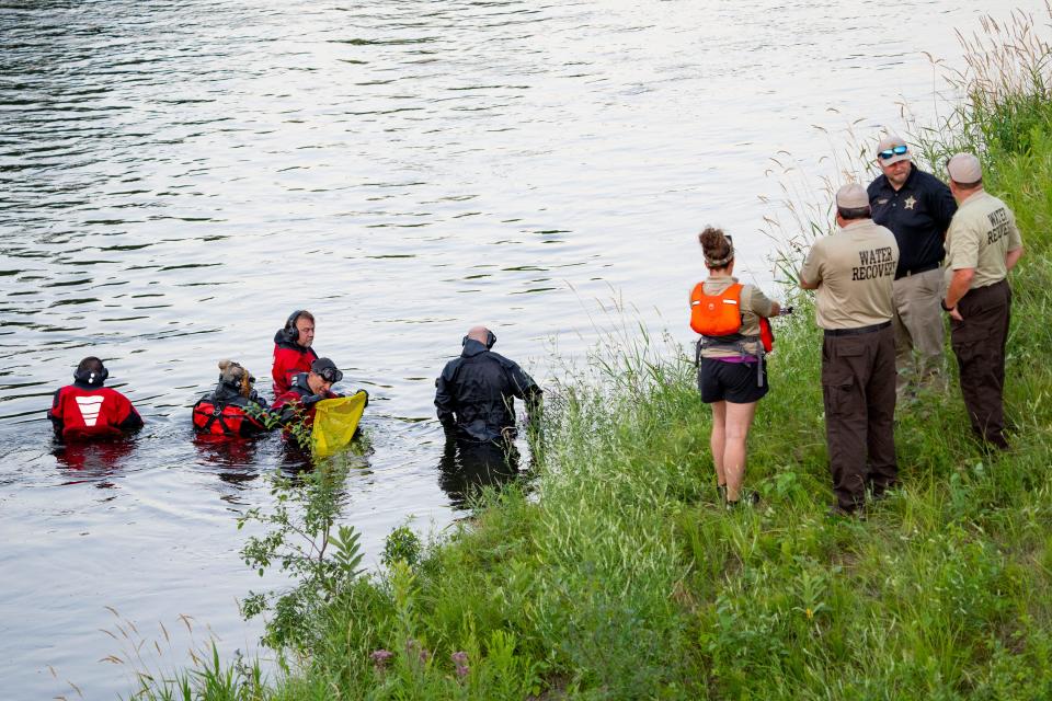 Water Recovery authorities comb the Apple River with metal detectors after five people were stabbed while tubing down the river Saturday, July 30, 2022, in Somerset, Wisconsin.