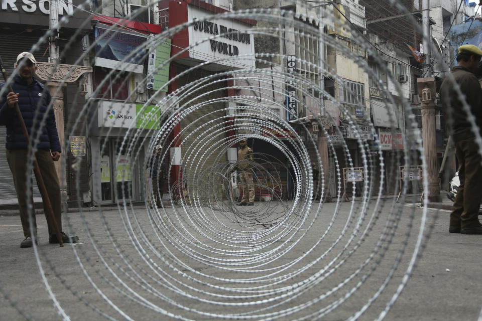 In this Sunday, Feb. 17, 2019, file photo, Indian police men keep vigil next to a barbed wire fencing during the third day of curfew in Jammu, India. The Indian army staged flag marches in sensitive localities, a day after violence was reported during protests against the Pulwama terror attack in which at least 40 soldiers were killed, officials said. (AP Photo/Channi Anand, File)