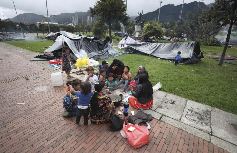 Miembros de la tribu Embera-Katio están sentados en un parque donde establecieron un refugio tras ser desalojados de sus horas por no pagar la renta debido a la pandemia del nuevo coronavirus en Bogotá, Colombia, el viernes 19 de junio de 2020. (AP Foto/Fernando Vergara)