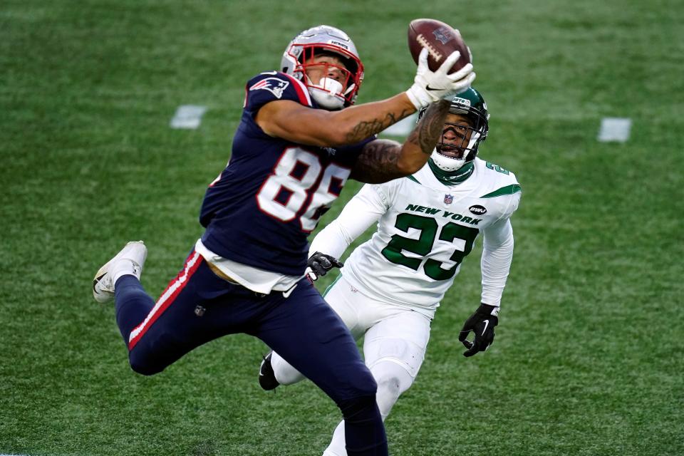 New England's Devin Asiasi catches a touchdown pass in front of New York's Arthur Maulet in the second half of Sunday's game.