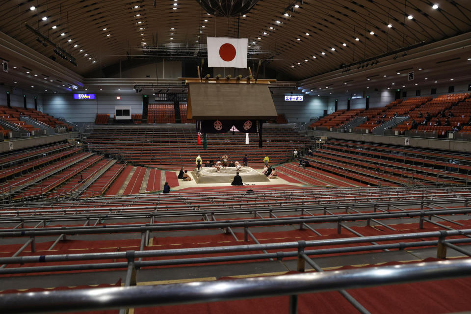 Spectators' seats are empty during a fight between sumo wrestlers at the Spring Grand Sumo Tournament in Osaka, western Japan, Sunday, March 8, 2020. The 15-day sumo tournament started on Sunday with no spectators, affected by fears of the new coronavirus outbreak. (Kyodo News via AP)