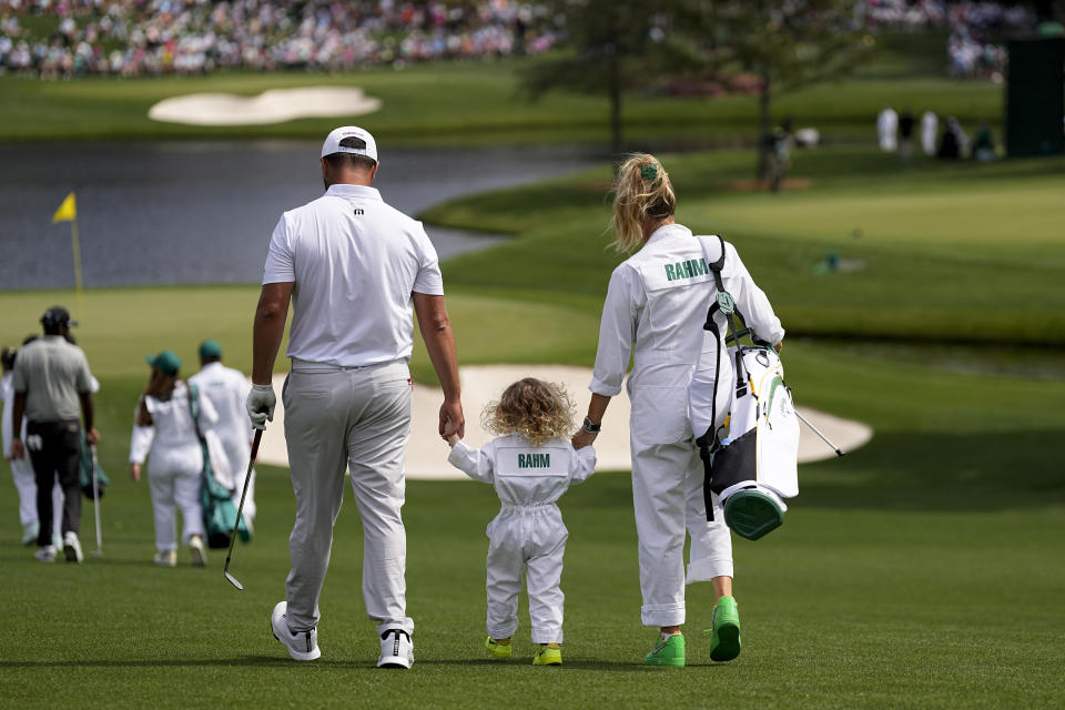 Jon Rahm, of Spain, walks with his wife, Kelley Cahill, and son, Kepa, on the third hole during the par-3 contest at the Masters golf tournament at Augusta National Golf Club Wednesday, April 10, 2024, in Augusta, GA. (AP Photo/George Walker IV)