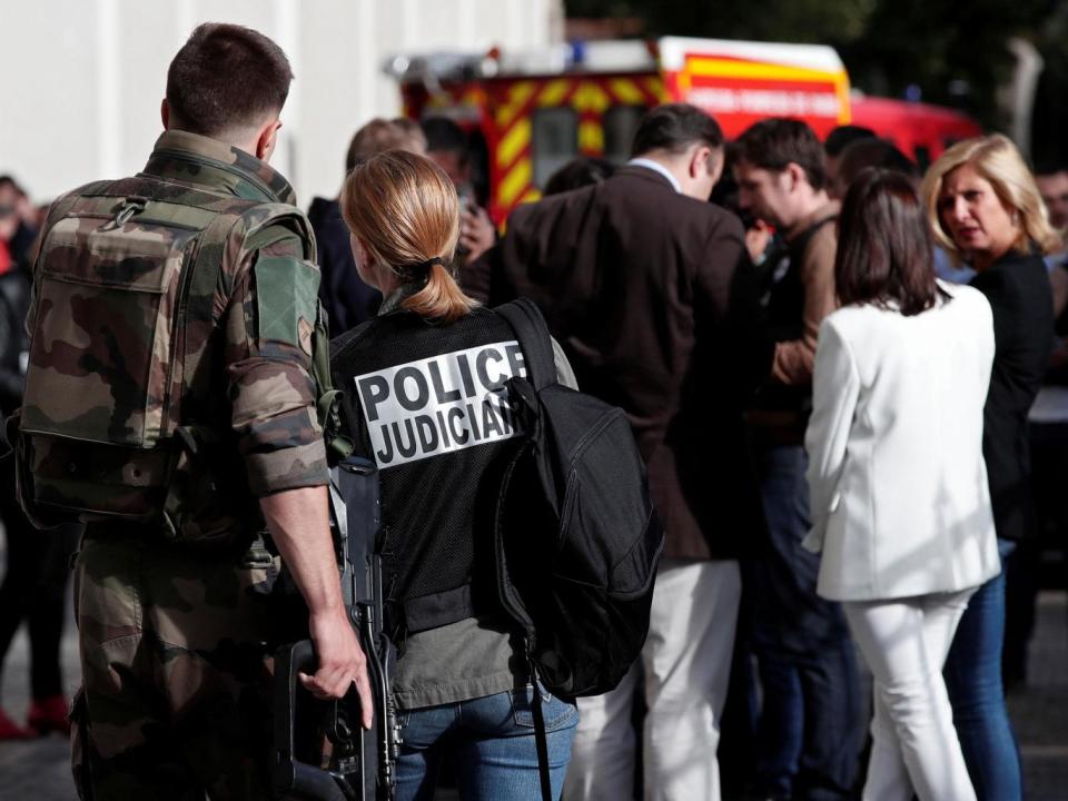 A police investigator and an armed soldier work near the scene (REUTERS/Benoit Tessier)