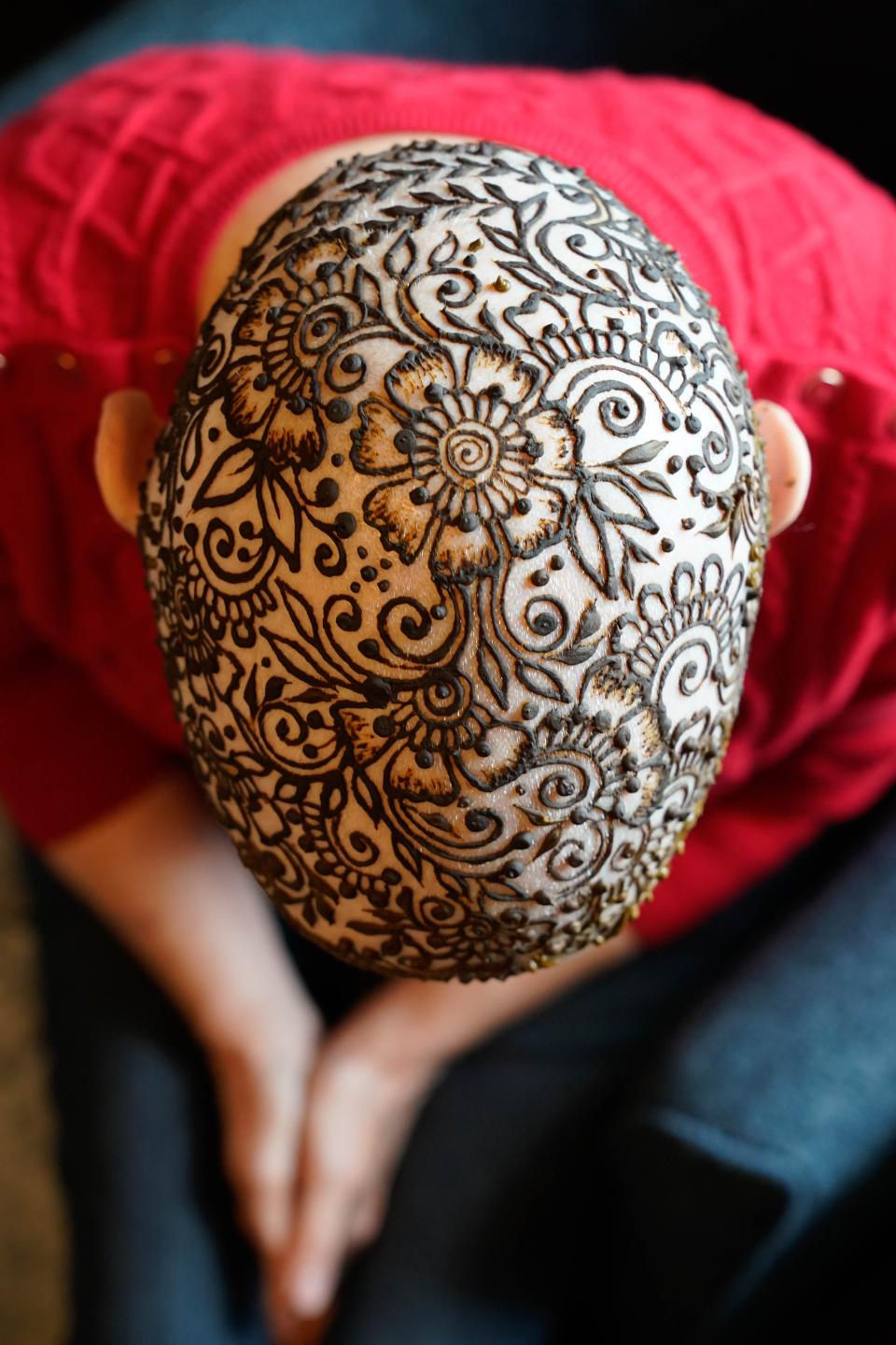 The finished henna crown on Bernice Schwartzman's head begins the drying process Friday morning. The artist, Vidhi Heiland, first started doing henna artwork as a child and recently made it into her business, Essential Henna.