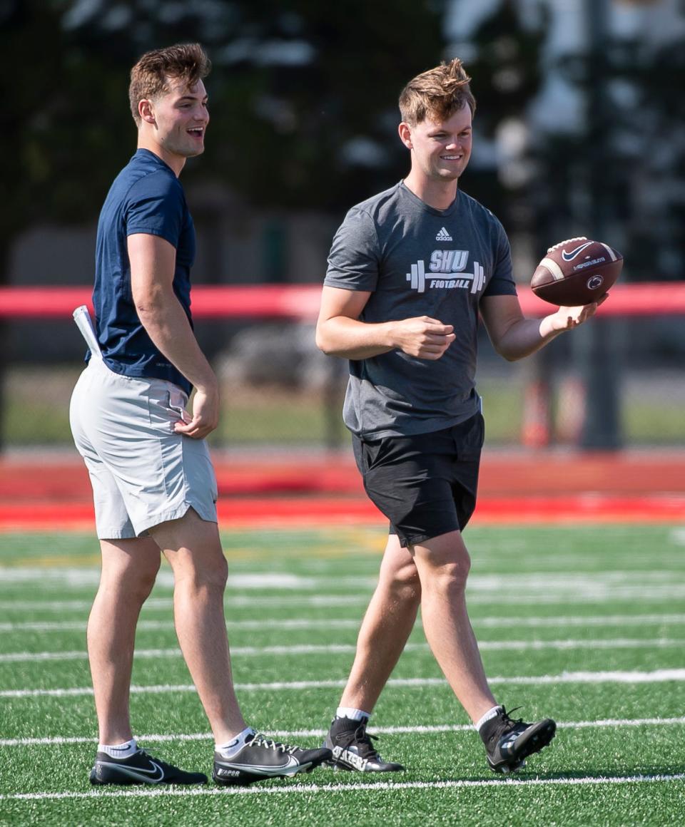Brothers Beau (left) and Cade Pribula laugh together during the start of their quarterback camp at Cumberland Valley High School May 21, 2023, in Mechanicsburg.