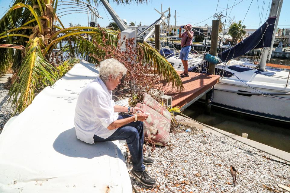 Kiko takes photos as Gordie rests on a piece of siding. They walked down their street to a neighbor's home to get photos to show to their friend. Agusto "Kiko" and Julia "Gordie" Villalon, long time Pine Island residents, returned to their Island home for the first time since evacuating before Hurricane Ian. Monday, September 03, 2022, they got to see just how much damage there was.