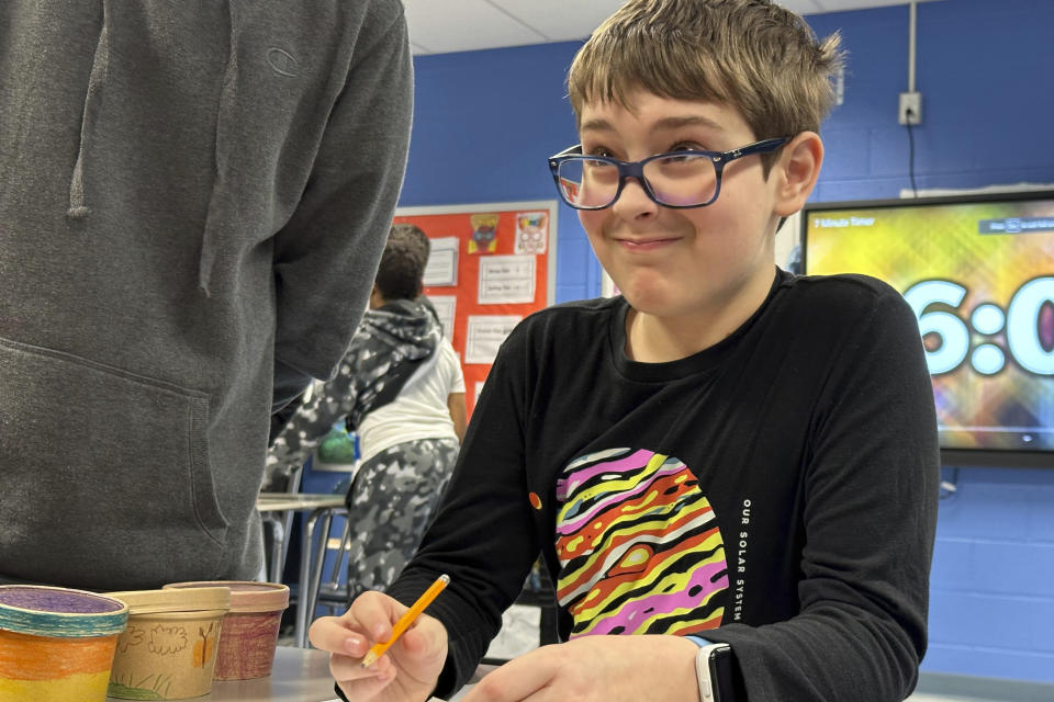 Seventh-grade student Henry Cohen wears a shirt picturing the solar system as he takes part in activities at Riverside Elementary School in Cleveland in preparation for the upcoming total eclipse of the sun. Teachers in or near the path of totality say they have worked to come up with educational and engaging lessons for the rare event. (AP Photo/Carolyn Thompson)