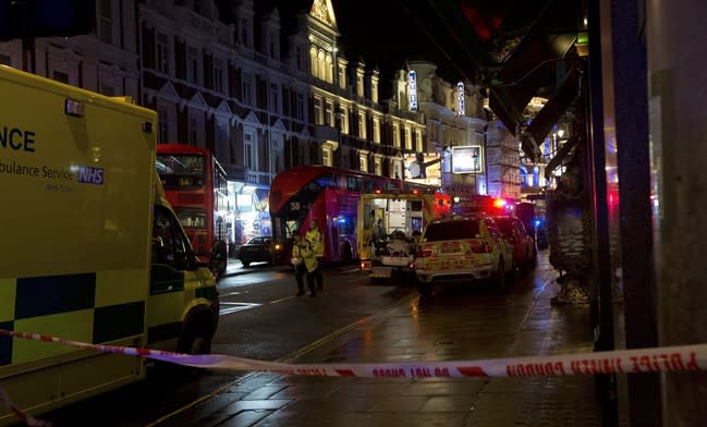 Emergency service vehicles gathered among London buses following an incident during a performance at the Apollo Theatre, far right, in London's Shaftesbury Avenue, Thursday evening, Dec. 19, 2013. It wasn't immediately clear if the roof, ceiling or balcony had collapsed. The London Fire Brigade said the theatre was almost full, with around 700 people watching the show. A spokesman said it was thought between 20 and 40 people were injured. (AP Photo by Joel Ryan, Invision)