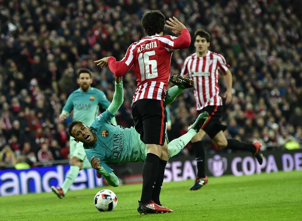 Barcelona's Neymar falls to the ground as he vies for the ball with Athletic Bilbao's Xabier Etxeita during the Spanish Copa del Rey, 16 round, first leg soccer match, between Athletic Bilbao and Barcelona, at San Mames stadium, in Bilbao, northern Spain, Thursday, Jan.5, 2017. FC Barcelona lost the match 2-1. (AP Photo/Alvaro Barrientos)