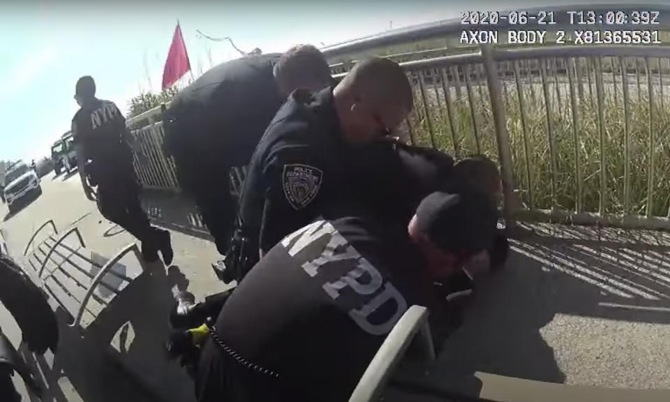 In this photo taken from police body cam video, New York Police officers arrest a man on a boardwalk Sunday, June 21, 2020, in New York. New York City Police Commissioner Dermot Shea says a police officer was quickly suspended without pay after putting his arm around the man's neck because we are living in "unprecedented times." Shea announced the suspension on Sunday just hours after the officer used what the commissioner called "an apparent chokehold" during a confrontation on a boardwalk in the Rockaway section of Queens. (NYPD via AP)