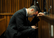 Oscar Pistorius, checks his mobile phone as he sits in the dock waiting for the proceedings of his murder trial to begin in court in Pretoria, South Africa, Tuesday, March 18, 2014. Pistorius is on trial for the murder of his girlfriend Reeva Steenkamp on Valentines Day, 2013. (AP Photo/Werner Beukes, Pool)