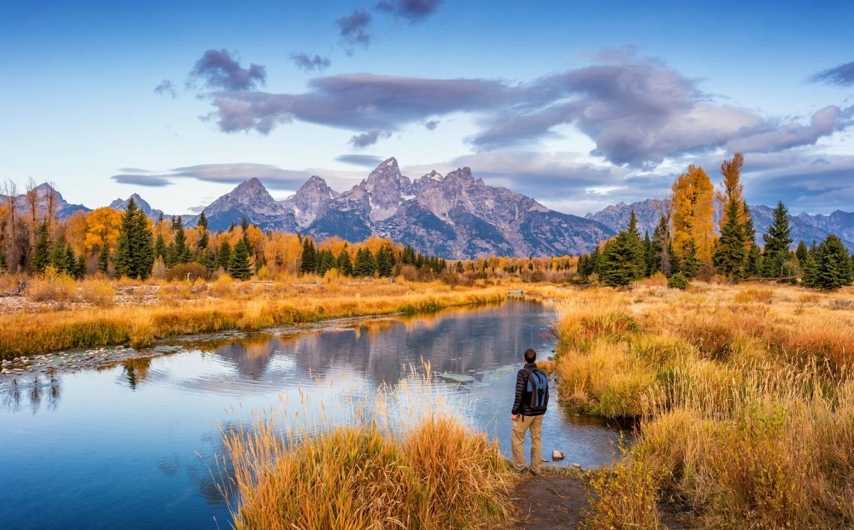 Stock photograph of hiker looking at view at Schwabacher Landing in Grand Teton National Park, Wyoming, USA, at dawn.