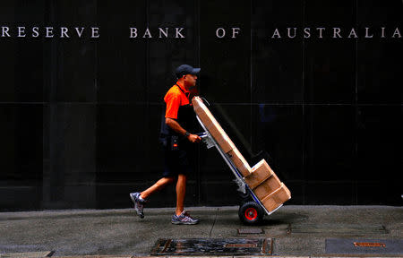 FILE PHOTO: A worker delivering parcels pushes a trolley past the Reserve Bank of Australia building in central Sydney, Australia, March 7, 2017. REUTERS/David Gray/File Photo