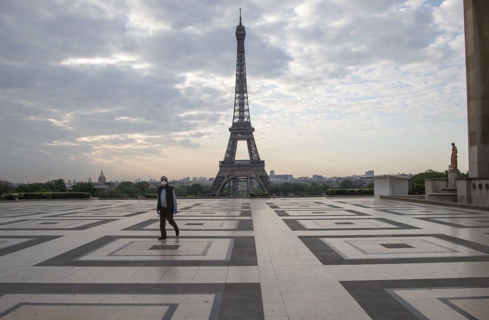 In this April 24, 2020, file photo, a man wears a mask to protect against the spread of the coronavirus as he walks along the Trocadero square close to the Eiffel Tower in Paris. (AP Photo/Michel Euler, File)