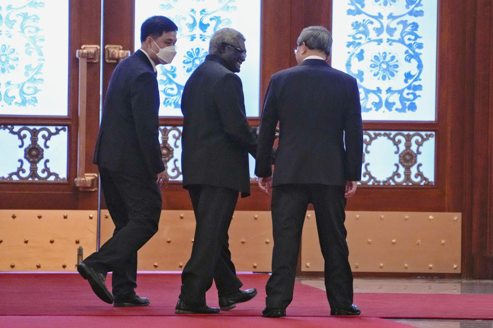 Visiting Solomon Islands Prime Minister Manasseh Sogavare, center, chats with his Chinese counterpart Li Qiang, right, during a welcome ceremony at the Great Hall of the People in Beijing, Monday, July 10, 2023. (AP Photo/Andy Wong, Pool)