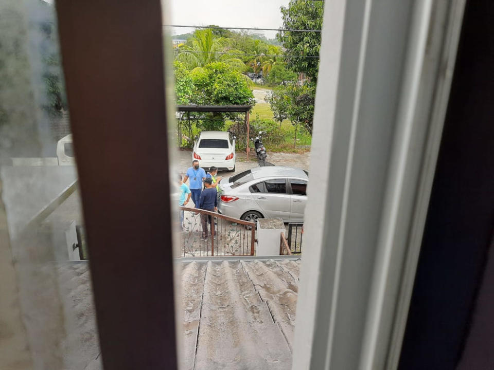 A picture shared on the activists’ Twitter accounts showing plainclothes policemen at the front gate of their house.