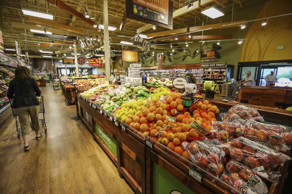 FILE - In this May 25, 2017, file photo, shoppers make their way around the new produce section in the newly-expanded City Market in Eagle, Colo. The supermarket is one of the most important places to be shopping-savvy. The good news is that there are so many easy and effective way to slash your grocery budget. Buy whole fruits and vegetables. Pound for pound, whenever you buy anything that has been peeled, cut up, or prepped in any way you are paying a premium. (Chris Dillmann/Vail Daily via AP, File)