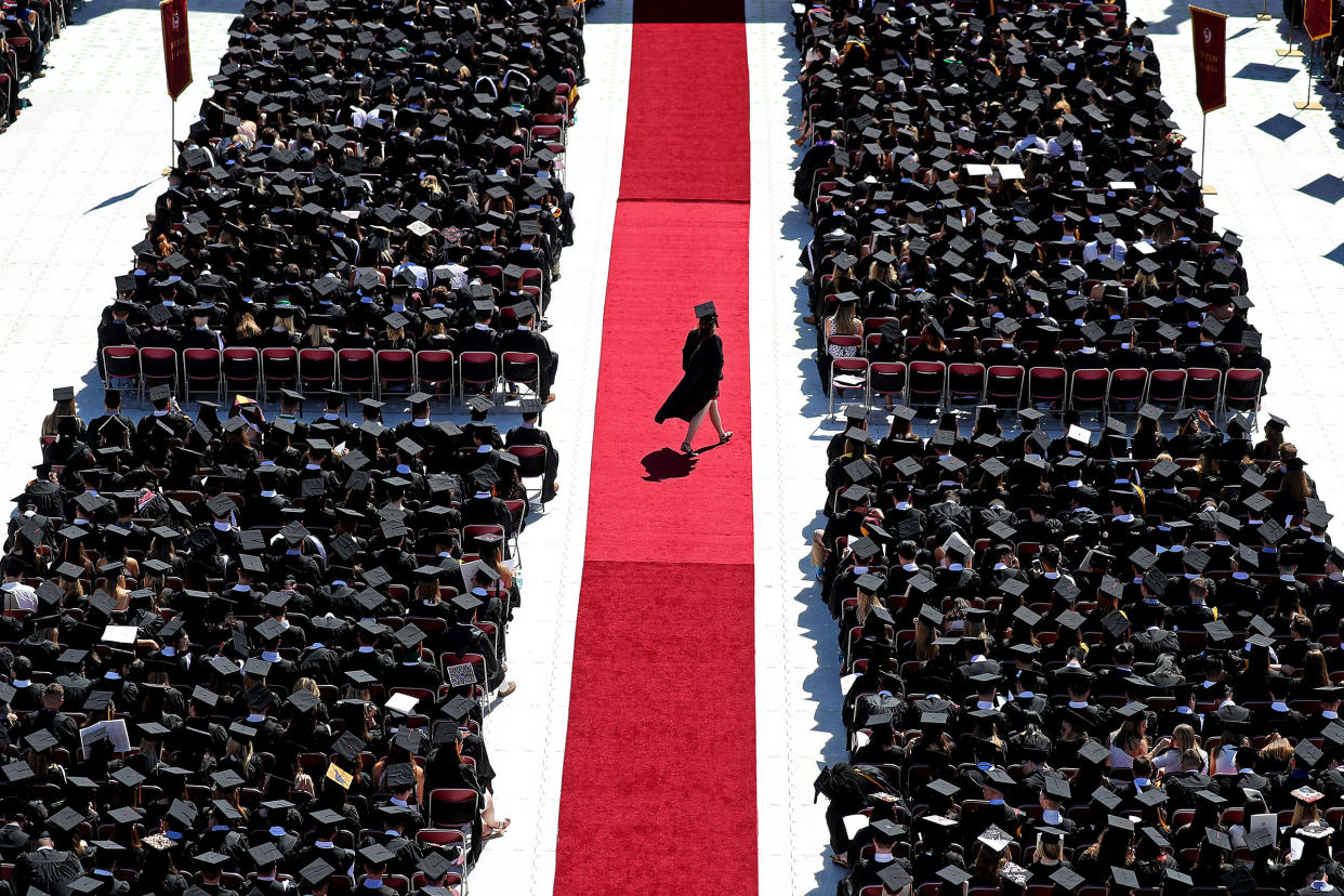 A graduate crosses the red carpet at Boston College’s commencement on May 21, 2018