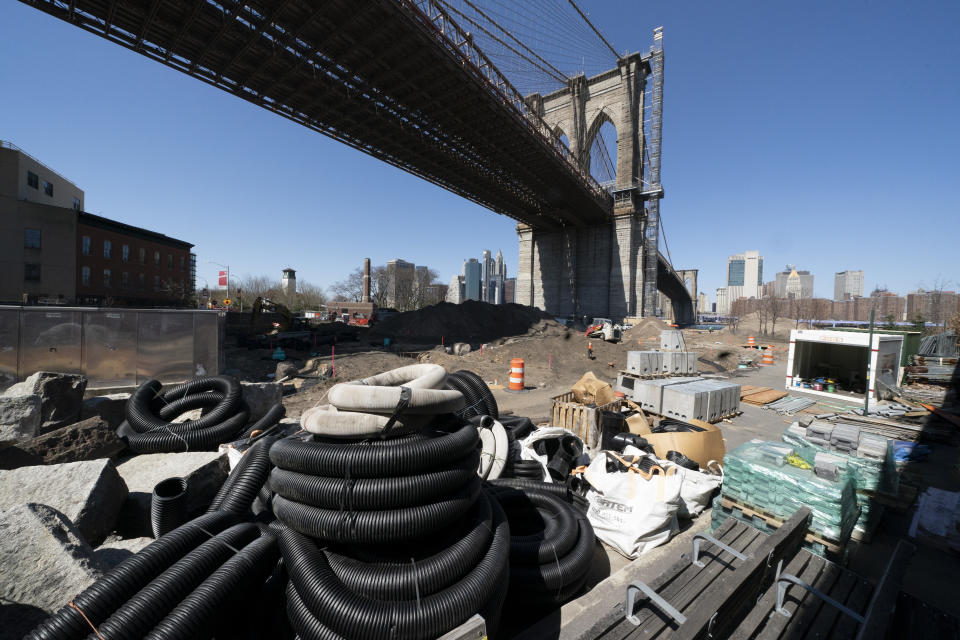 Work continues on the Emily Roebling Plaza underneath the Brooklyn Bridge, Tuesday, April 6, 2021 in New York. With an appeal to think big, President Joe Biden is promoting his $2.3 trillion infrastructure plan directly to Americans. Republicans oppose Biden's American Jobs Plan as big taxes, big spending and big government. (AP Photo/Mark Lennihan)