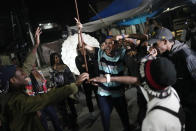 Rappers and fans cheer during the Gas Battle rapping competition outside a bar in the City of God favela in Rio de Janeiro, Brazil, late Wednesday, Nov. 10, 2021. Rap artists in the favela are starting to compete again since the COVID-19 pandemic curtailed public gatherings, presenting local residents with a show in a sign of a return to normalcy for music lovers. (AP Photo/Silvia Izquierdo)