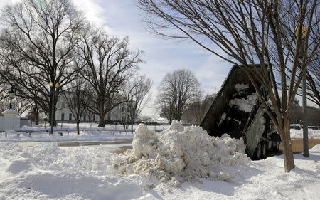 A dump truck piles a load of snow in front of the White House after a major winter storm swept over Washington January 25, 2016. REUTERS/Joshua Roberts