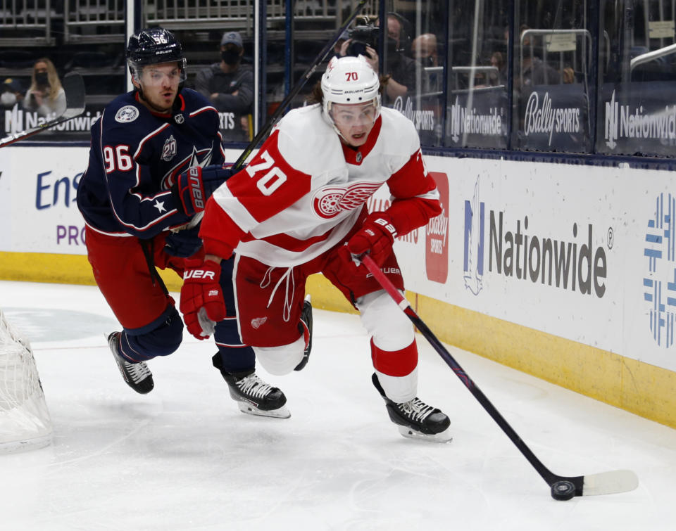 Detroit Red Wings defenseman Troy Stecher, right, controls the puck in front of Columbus Blue Jackets forward Jack Roslovic during the second period of an NHL hockey game in Columbus, Ohio, Saturday, May 8, 2021. (AP Photo/Paul Vernon)