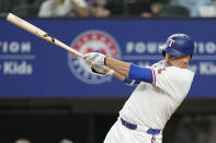 Texas Rangers' Nathaniel Lowe follows through on an RBI single in the seventh inning of a baseball game against the Washington Nationals in Arlington, Texas, Tuesday, April 30, 2024. Marcus Semien scored on the hit. (AP Photo/Tony Gutierrez)