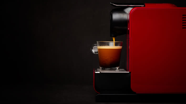 red Nespresso machine pulling shot