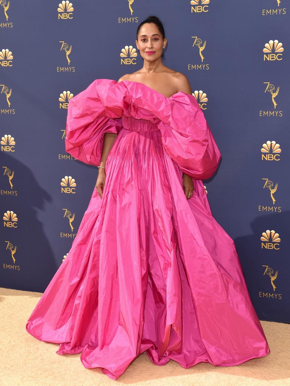 <p>Tracee Ellis Ross brought the drama to the 2018 Emmy Awards in this hot pink Valentino couture gown with super-puffed sleeves. The Blackish actress finished her look with Repossi jewellery, a slicked-back chignon and bold neon make-up. </p>