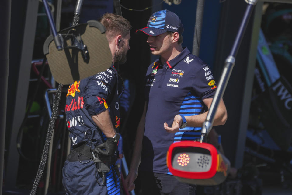 Red Bull driver Max Verstappen, right, of the Netherlands gestures as he talks with a teammate after retiring from the Australian Formula One Grand Prix at Albert Park, in Melbourne, Australia, Sunday, March 24, 2024. (AP Photo/Scott Barbour)