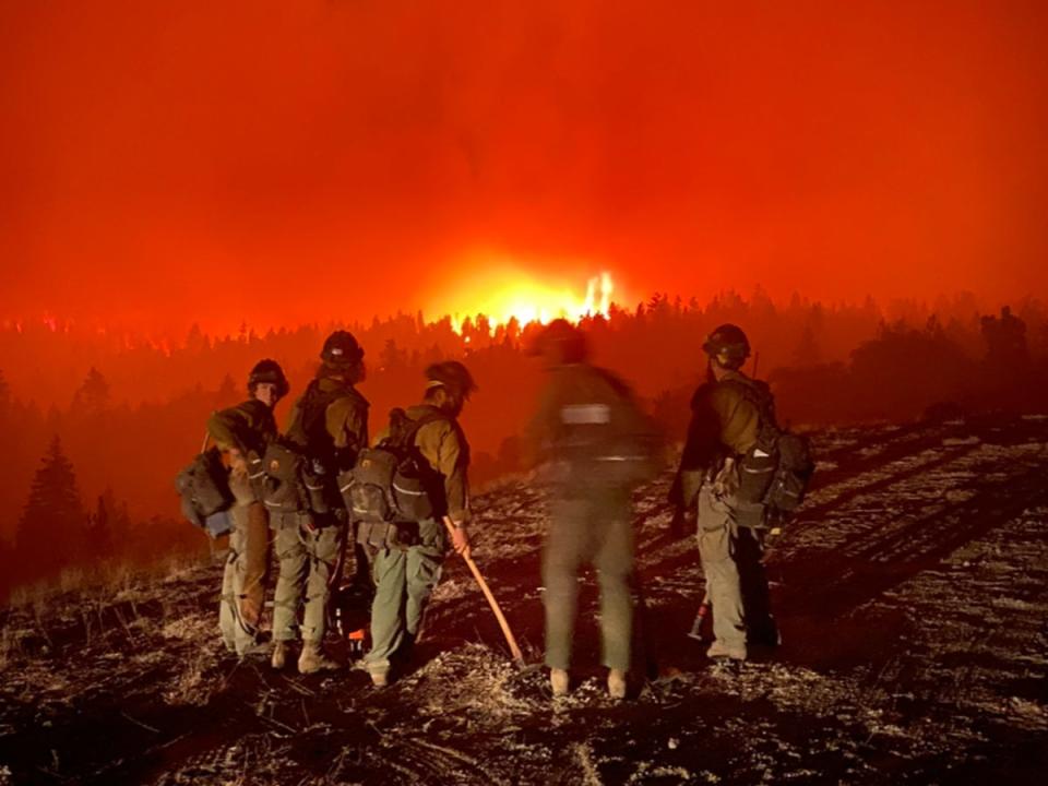 Wildland firefighters monitor a large blaze as they prepare to ‘spike out’ - spend the night under tarp without camping gear (Courtesy of Ben McLane)