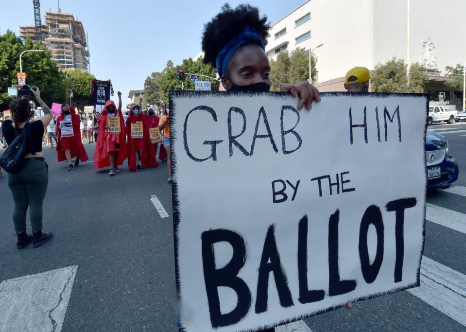 Female protester holding up "Grab him by the ballot" sign