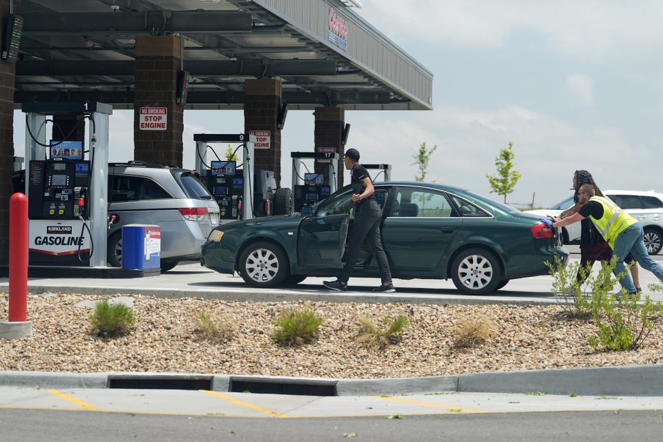 A motorist gets help reaching the gasoline pumps at a Costco warehouse Friday, May 31, 2024, in Aurora, Colo. (AP Photo/David Zalubowski)