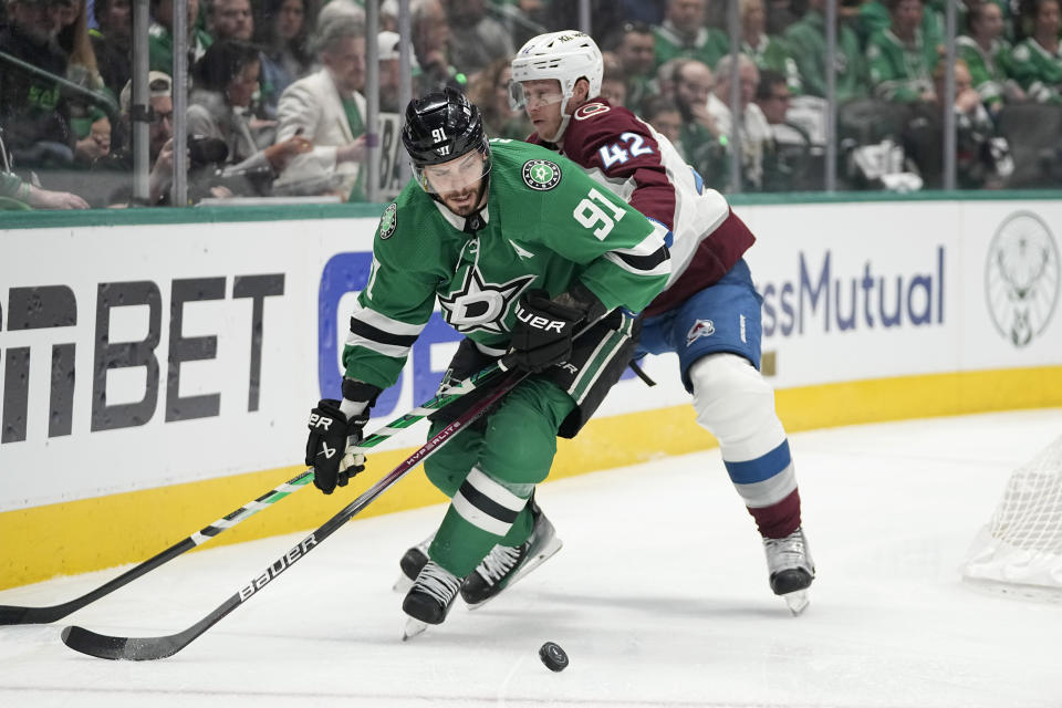 Dallas Stars center Tyler Seguin (91) and Colorado Avalanche defenseman Josh Manson (42) compete for the puck during the first period in Game 2 of an NHL hockey Stanley Cup second-round playoff series in Dallas, Thursday, May 9, 2024. (AP Photo/Tony Gutierrez)