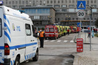 A security guard directs an ambulance arriving at the Santa Maria hospital as more than a dozen others queue waiting to hand over their COVID-19 patients to medics, Friday, Jan. 22, 2021. Portugal's COVID-19 surge is continuing unabated, with a new record of daily deaths, hospitalizations and patients in intensive care. (AP Photo/Armando Franca)