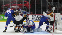 Germany's and Slovakia's players challenge in front of Slovakia's keeper Patrik Rybar during the group A Hockey World Championship match between Slovakia and Germany in Helsinki, Finland, Saturday May 14, 2022. (AP Photo/Martin Meissner)