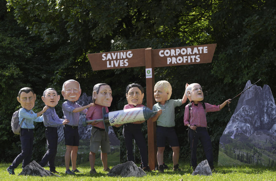 Activists from Oxfam wear giant heads of G7 leaders as they pose with a giant syringe during a demonstration in Munich, Germany, Saturday, June 25, 2022. The G7 Summit will take place at Castle Elmau near Garmisch-Partenkirchen from June 26 through June 28, 2022. Leaders depicted from left, French President Emmanuel Macron, Japan's Prime Minister Fumio Kishida, U.S. President Joe Biden, Italy's Prime Minister Mario Draghi, Canada's Prime Minister Justin Trudeau, British Prime Minister Boris Johnson and German Chancellor Olaf Scholz. (AP Photo/Matthias Schrader)