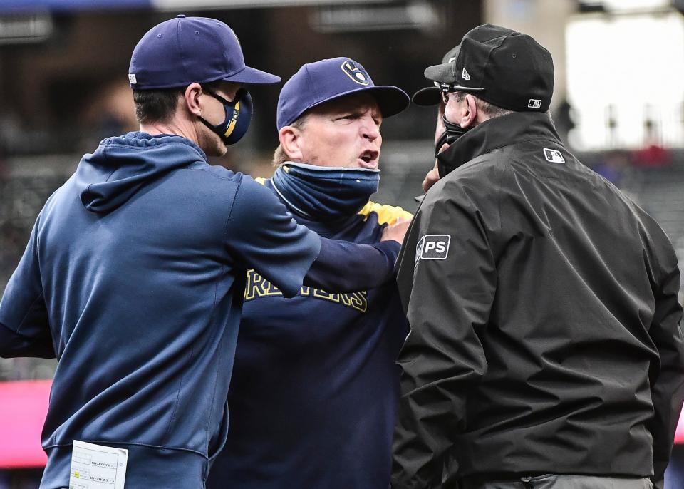 Milwaukee Brewers bench coach Pat Murphy (middle) is restrained by manager Craig Counsell (left) while arguing with first base umpire Marty Foster in the fourth inning during the game against the Miami Marlins at American Family Field on April 28, 2021, in Milwaukee, Wis.