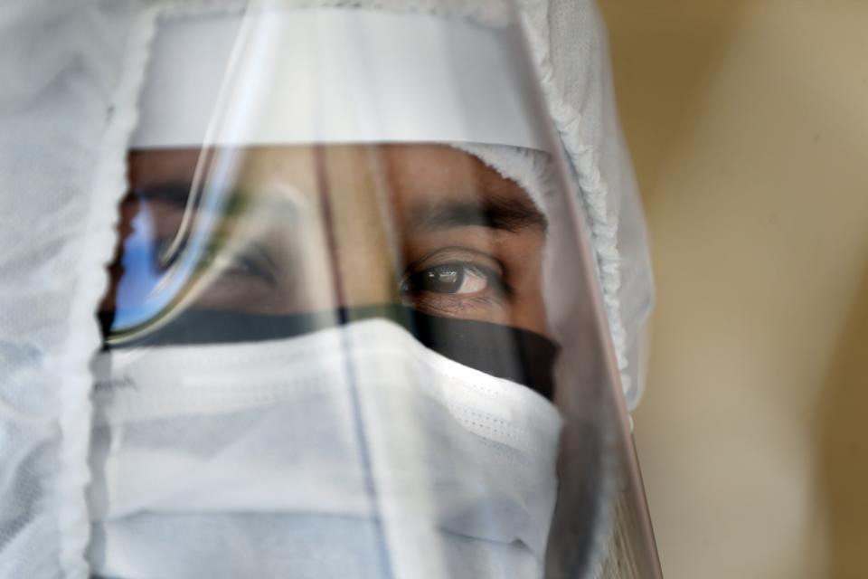 A nurse waits to take COVID-19 tests to travelers at a Health Ministry checkpoint in Asuncion, Paraguay, Monday, April 20, 2020. (AP Photo/Jorge Saenz)