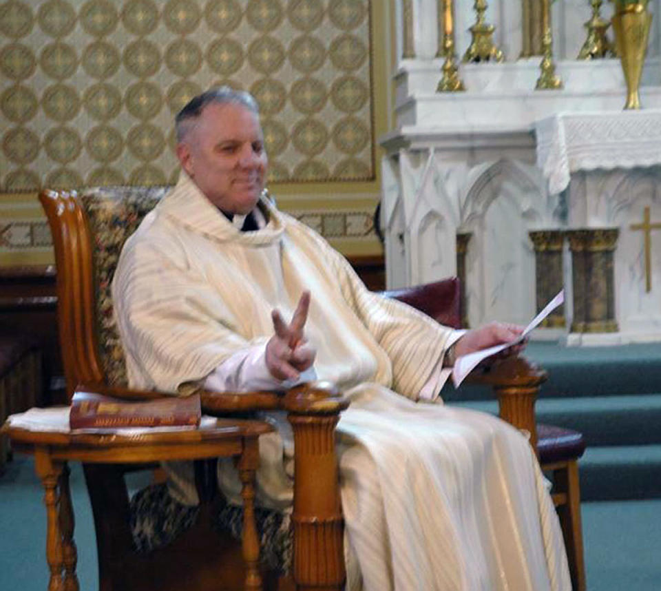 This undated photo provided by Lynn Enemark shows the Rev. Eric Freed in St. Bernard Catholic Church in Eureka, Calif. Freed was found slain in the church rectory on New Year's Day. Police have arrested a man who was in jail the day before Freed's body was found, then released after an evaluation at a hospital. (AP Photo/Lynn Enemark) NO SALES