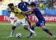 Colombia's Juan Cuadrado (L) fights for the ball with Japan's Shinji Kagawa during their 2014 World Cup Group C soccer match at the Pantanal arena in Cuiaba June 24, 2014. REUTERS/Jorge Silva (BRAZIL - Tags: SOCCER SPORT WORLD CUP)