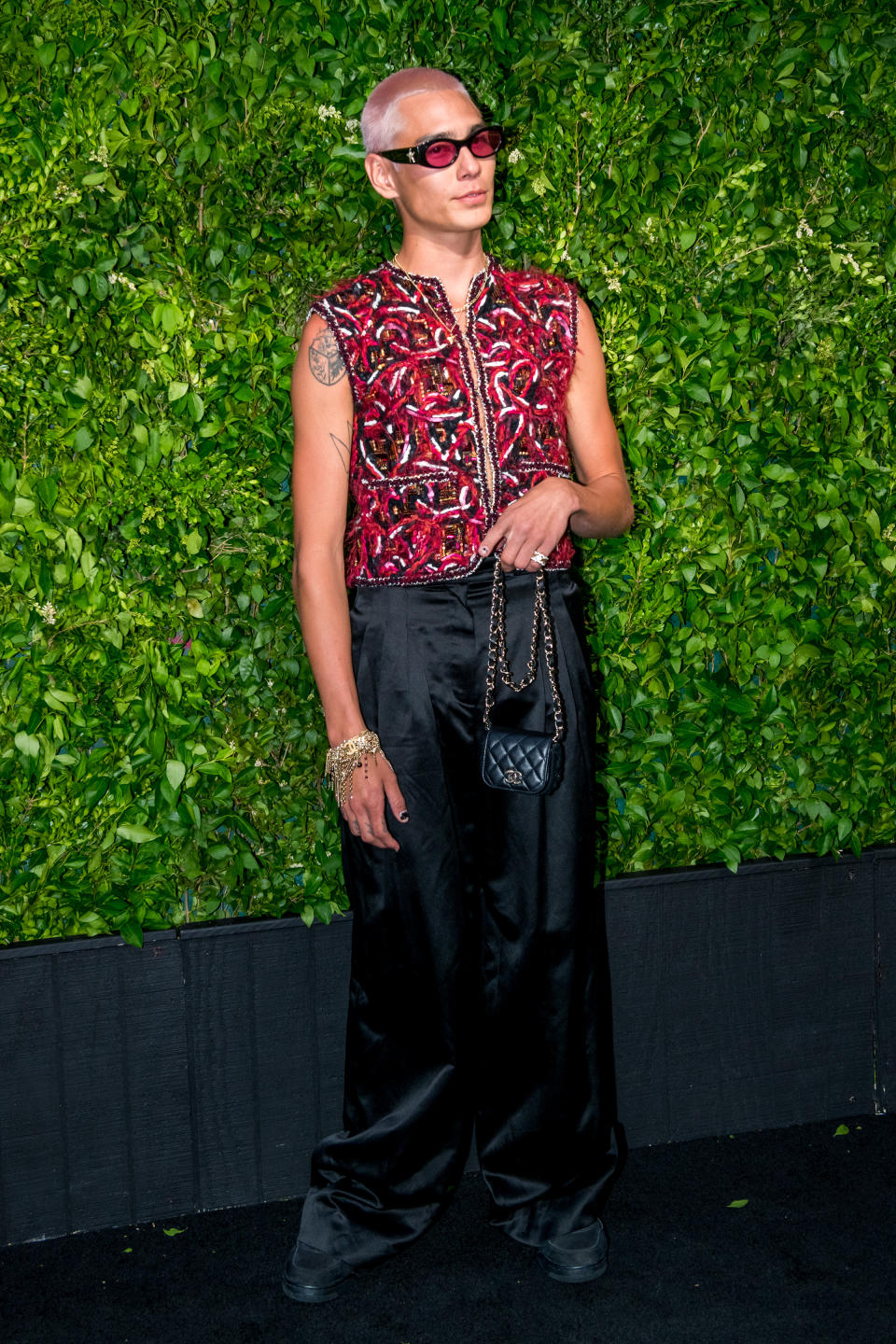 Evan Mock carrying a Chanel mini-bag on the carpet before the dinner. - Credit: Darian DiCianno/BFA.com