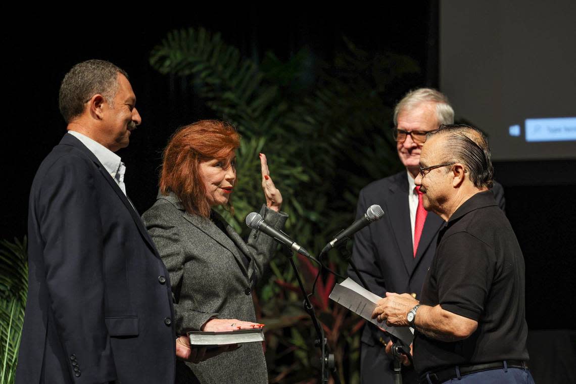 Brenda Fam, second from left, is sworn into office by both Domingo Vasquez, right, and Tom Powers during a ceremony for the five newly elected Broward School Board members on Tuesday, Nov. 22, 2022, at Fort Lauderdale High School.