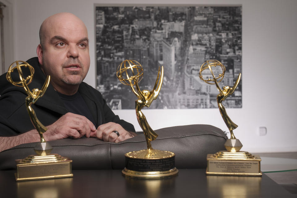 Emmy Award-winning producer Johnathan Walton poses for a photo with his Emmy Awards at his apartment in downtown Los Angeles, Monday, March 25, 2024. Walton was scammed by con artist Marianne "Mair" Smyth, who is now facing extradition to the United Kingdom. Walton started a podcast in 2021, “Queen of the Con,” to warn others about Smyth after he said he was fleeced out of nearly $100,000. (AP Photo/Damian Dovarganes)