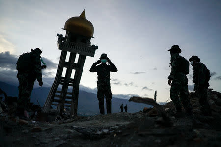 Soldiers take a break near a destroyed mosque where they found earthquake victims in the Balaroa neighbourhood in Palu, Central Sulawesi, Indonesia, October6, 2018. REUTERS/Athit Perawongmetha
